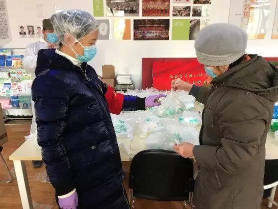 為樓棟分發(fā)口罩，并為包裝袋消毒